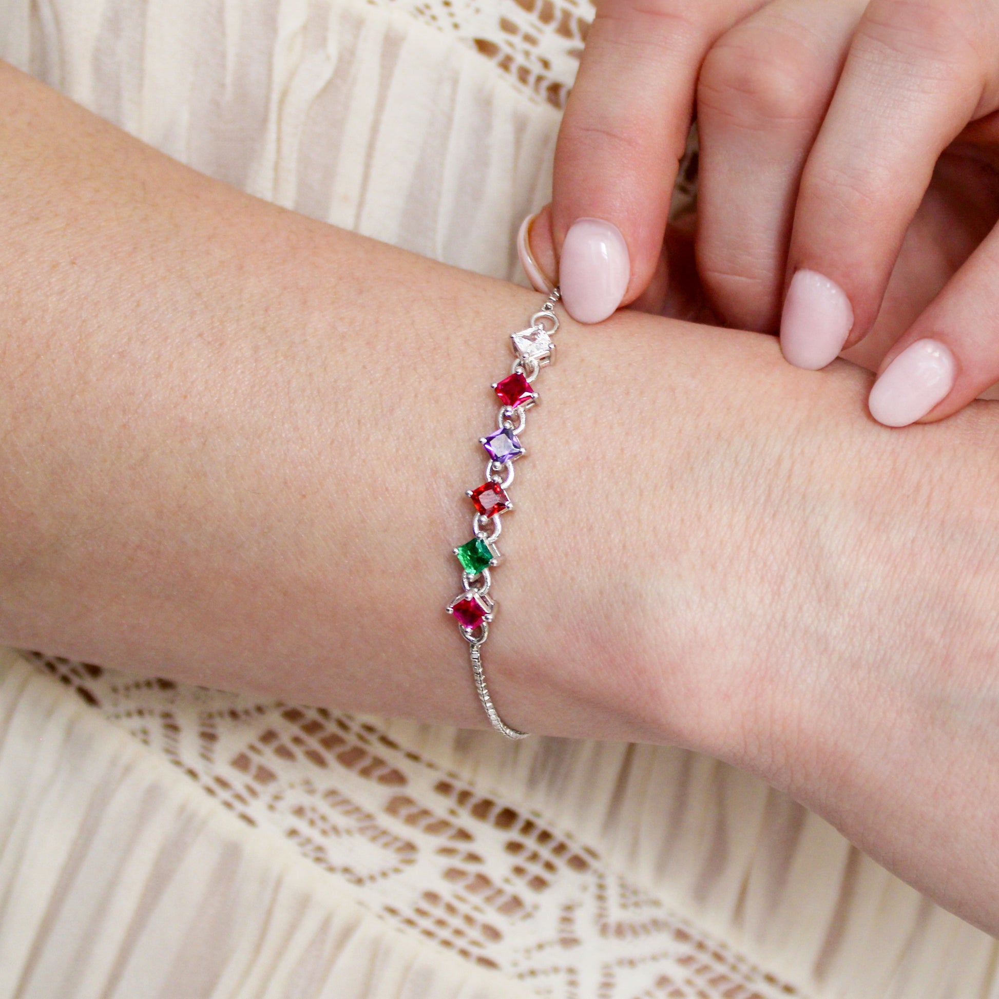 Linked Love Bracelet in sterling silver on model, hand touching acrostic REGARD CZ bracelet with Linked Love Necklace in background, Ether Jewelry