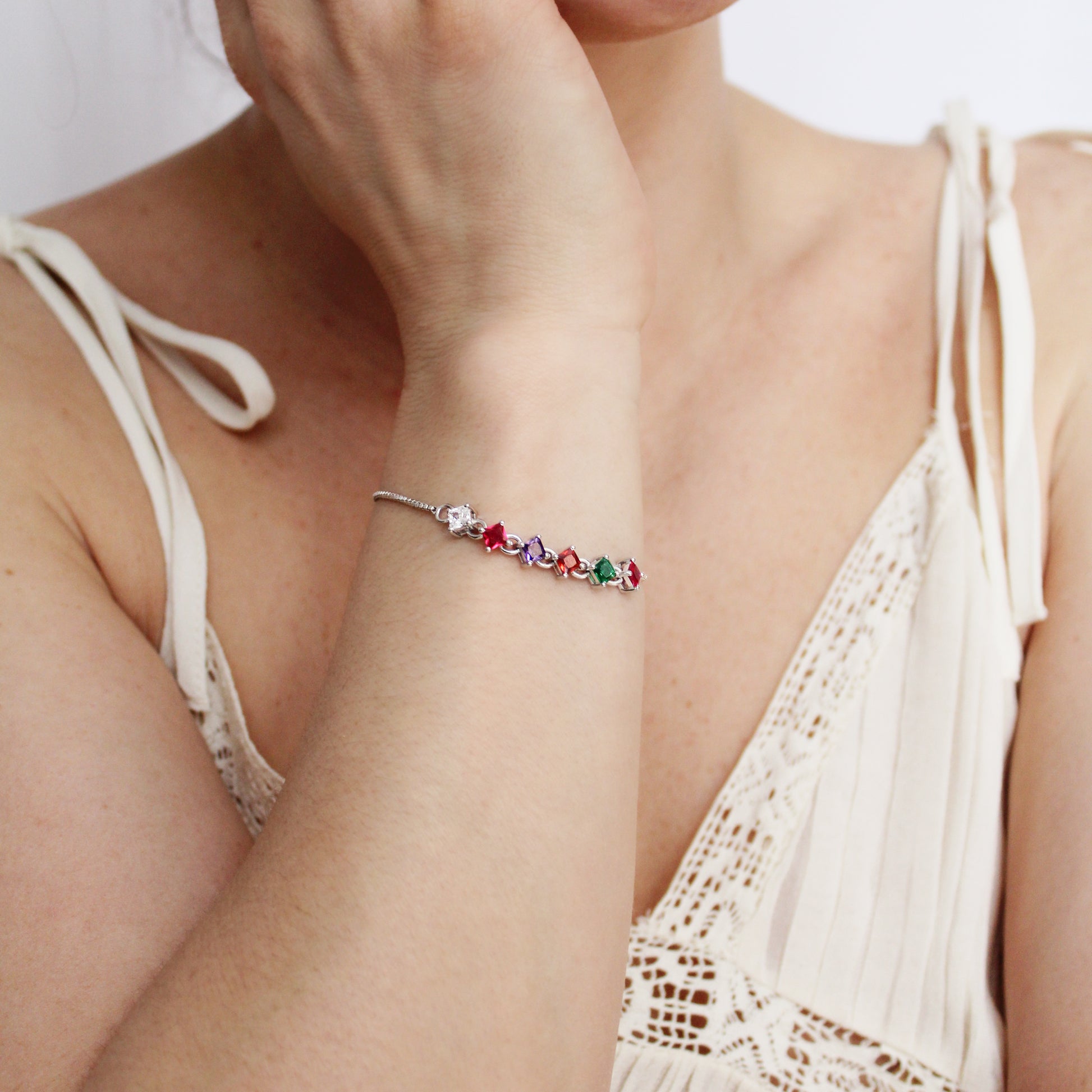 inked Love Bracelet in sterling silver on model holding wrist up, acrostic REGARD CZ bracelet with Linked Love Necklace in background, Ether Jewelry