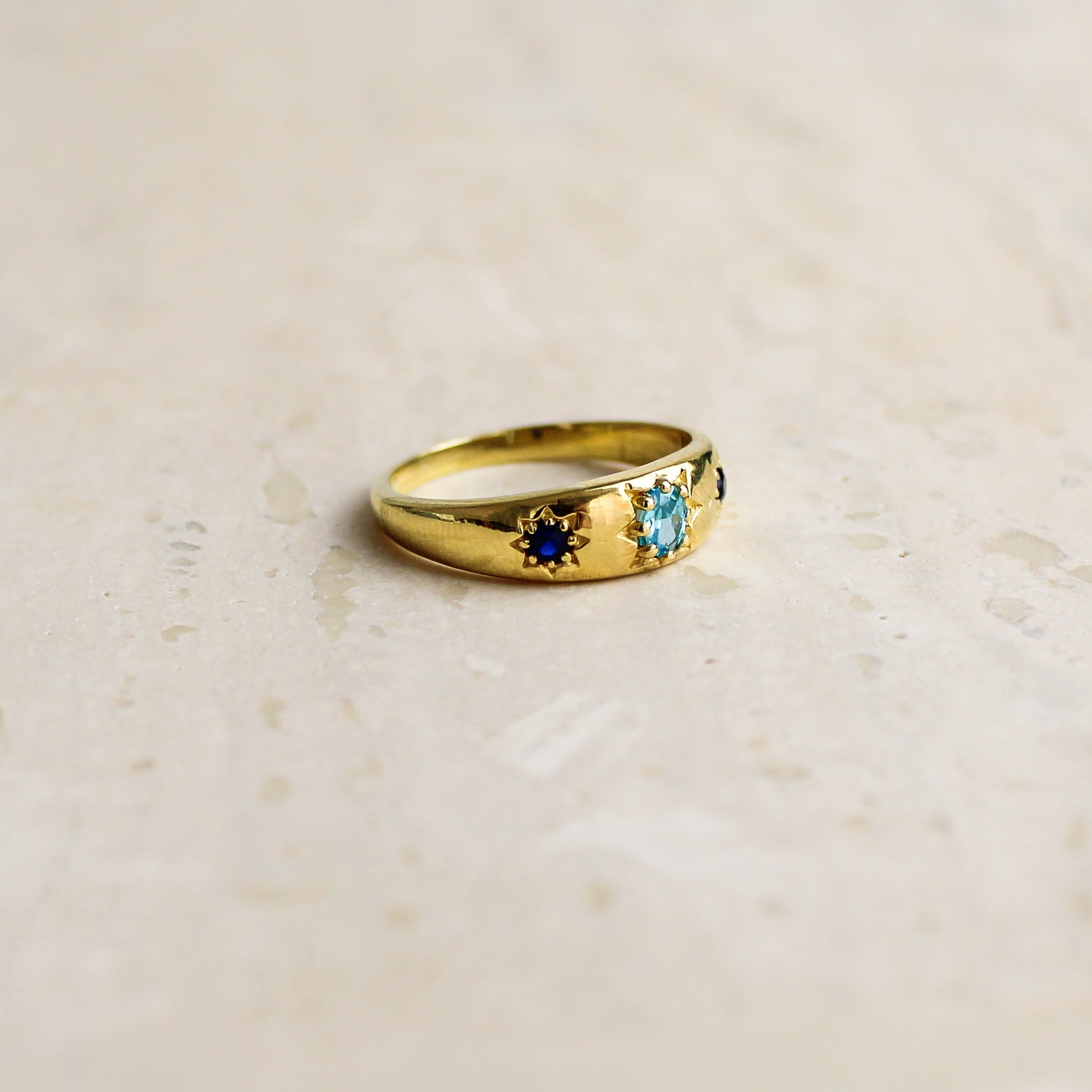 Letters from Roma Ring 18k gold vermeil side view on marble, light blue CZ center star-set blue CZ domed band, Ether Jewelry