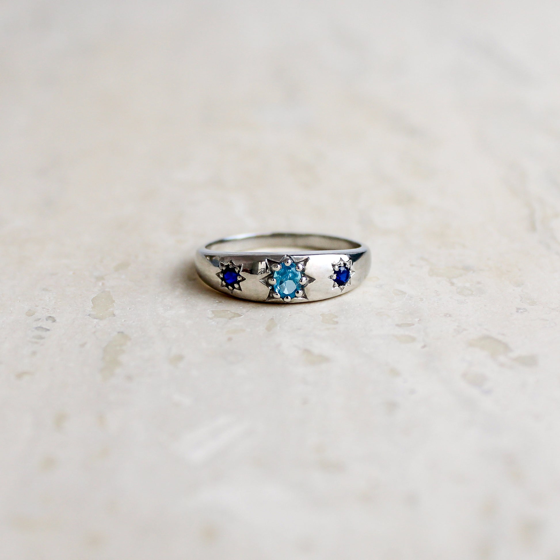 Letters from Roma Ring sterling silver on marble, domed three stone gypsy set band with light blue and blue CZ, Ether Jewelry