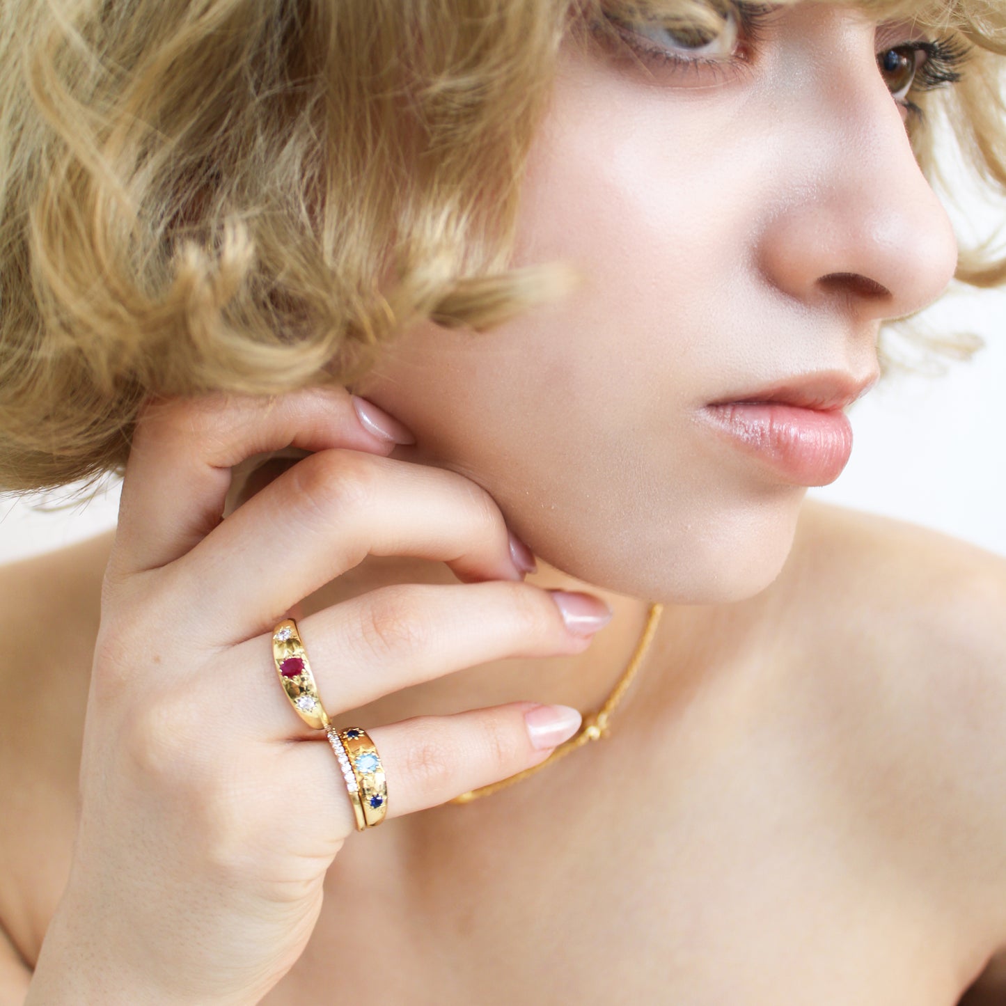 18k gold vermeil Letters from Roma Ring close-up on model hand, three stone gypsy set domed band, Ether Jewelry
