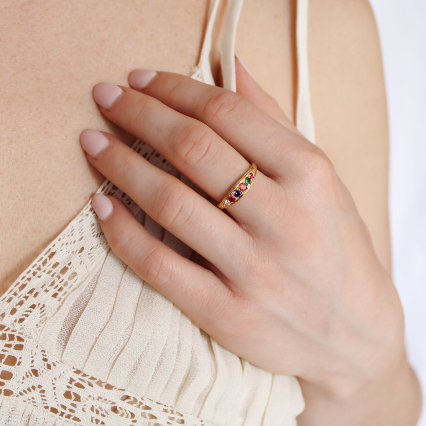 Love Letter Ring in 18k gold vermeil worn on model hand on chest in beige dress, acrostic REGARD ring, Ether Jewelry