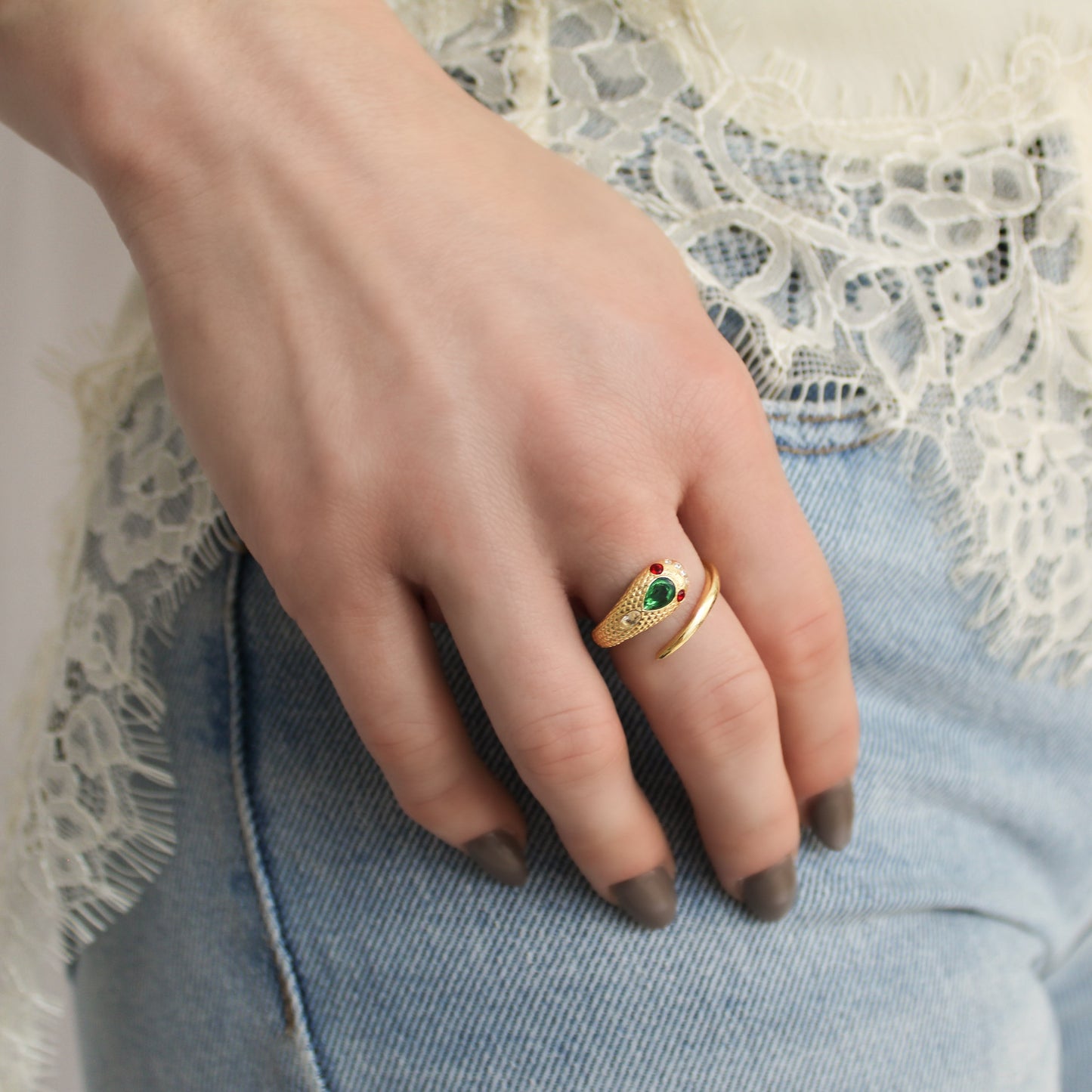 Gold vermeil serpent ring styled on model hand in pocket of jeans and lace shirt, ether jewelry