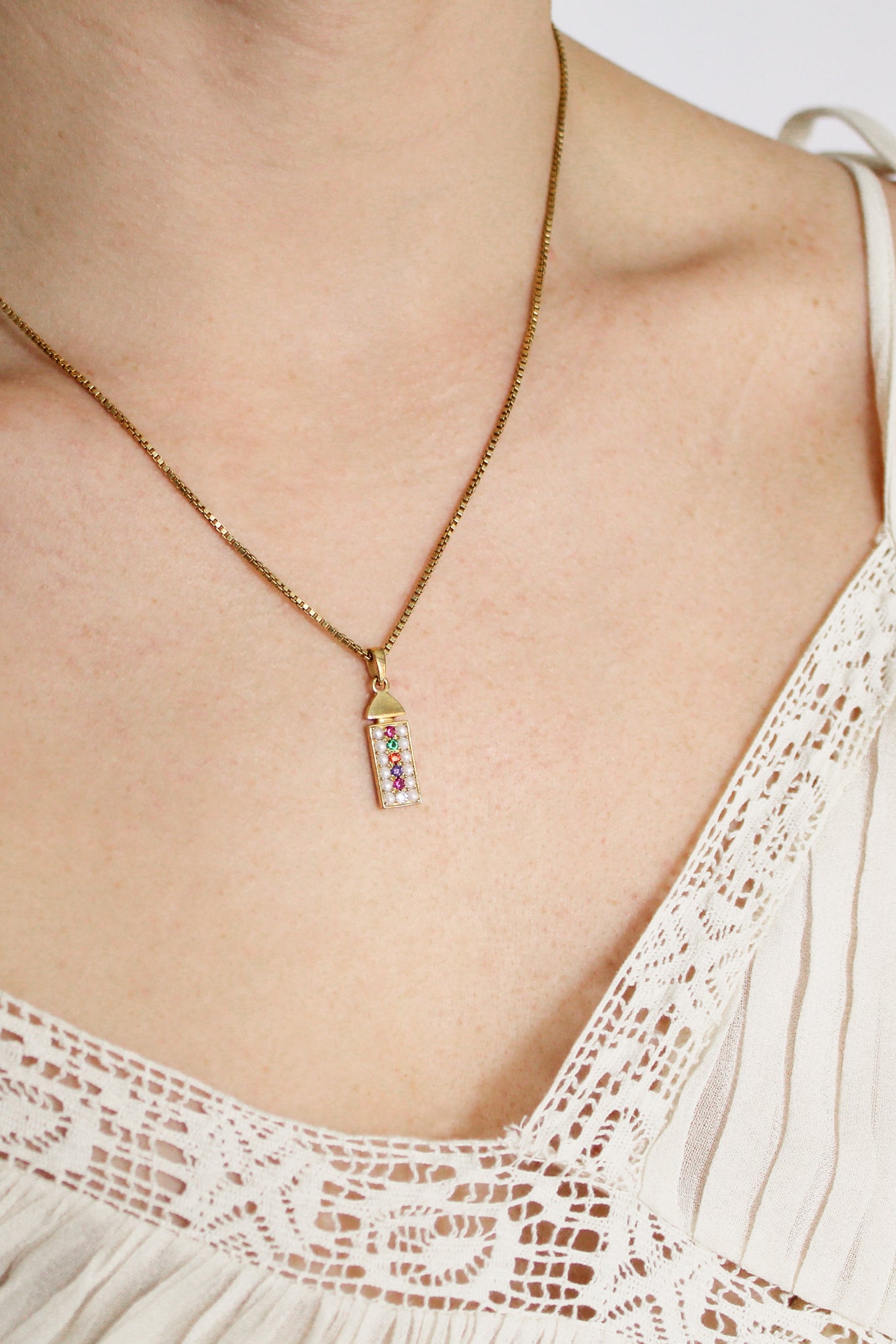 Regent 18k gold vermeil necklace on model side view, pearl-paved acrostic rectangular pendant with domed cap, Ether Jewelry