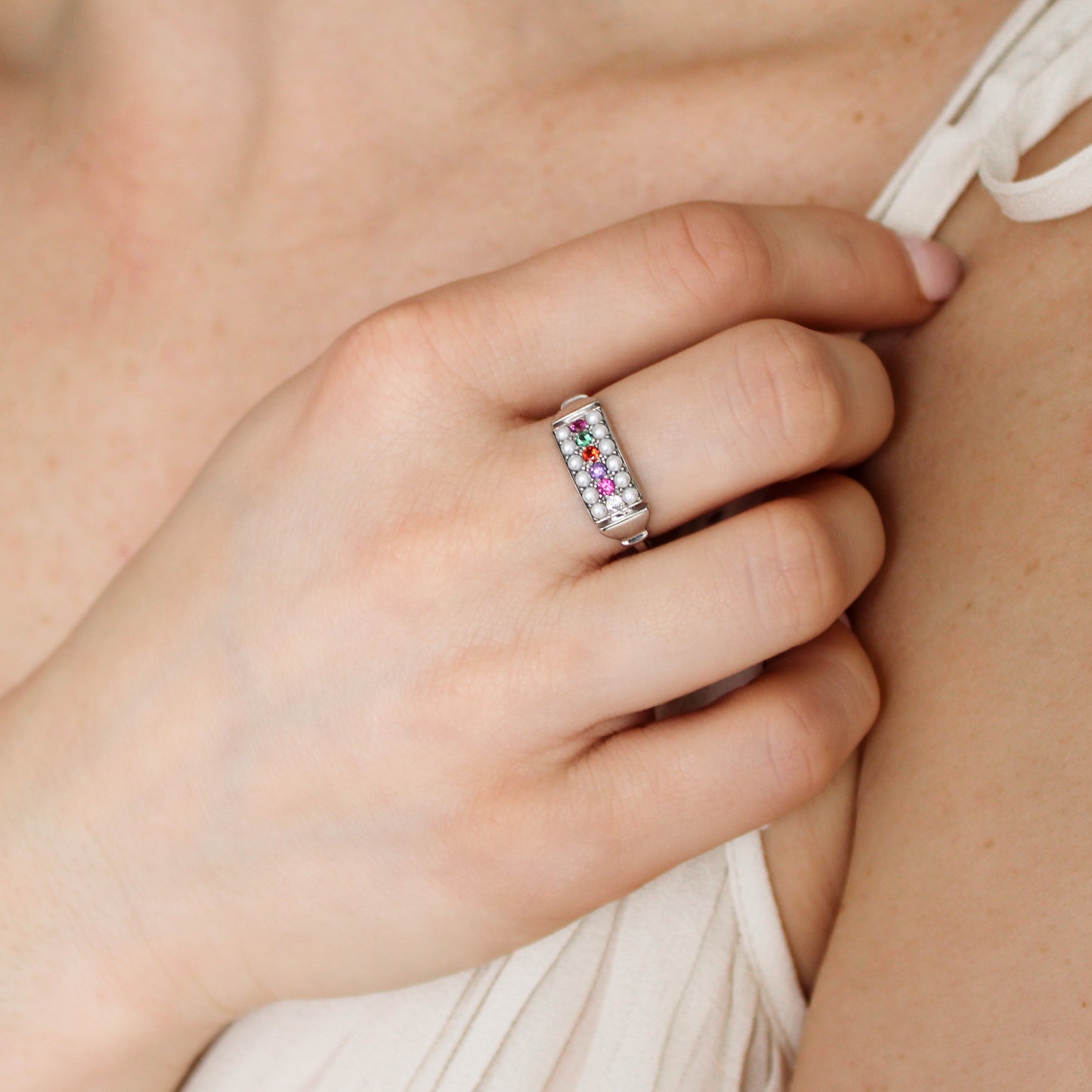 Sterling silver Regent Ring on model holding up hand, cultured pearl and acrostic gemstone signet ring, Ether Jewelry