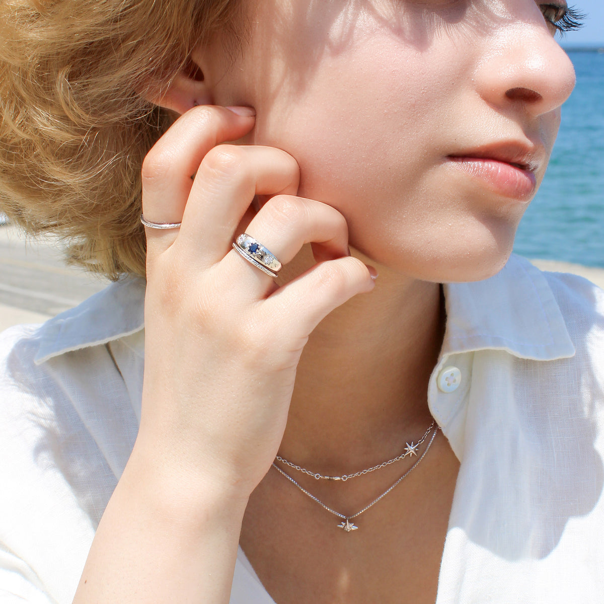 Sterling silver Victorian Roma Ring on model with all Roma rings on hand in front of face, matching necklaces, Ether Jewelry