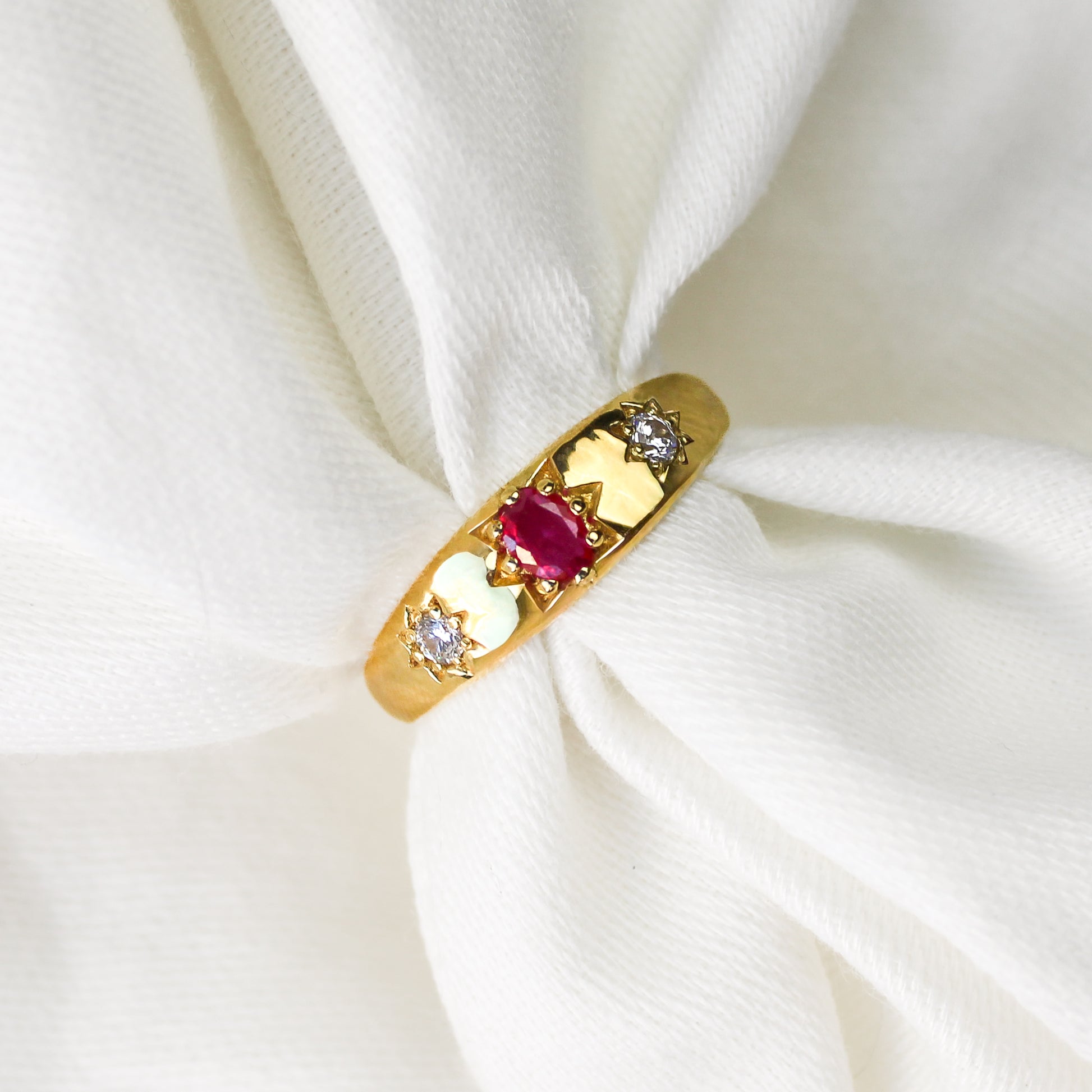 Rose from Roma Ring in 18k gold vermeil, domed gypsy band with pink CZ center and two star-set white CZ side stones on white fabric, Ether Jewelry