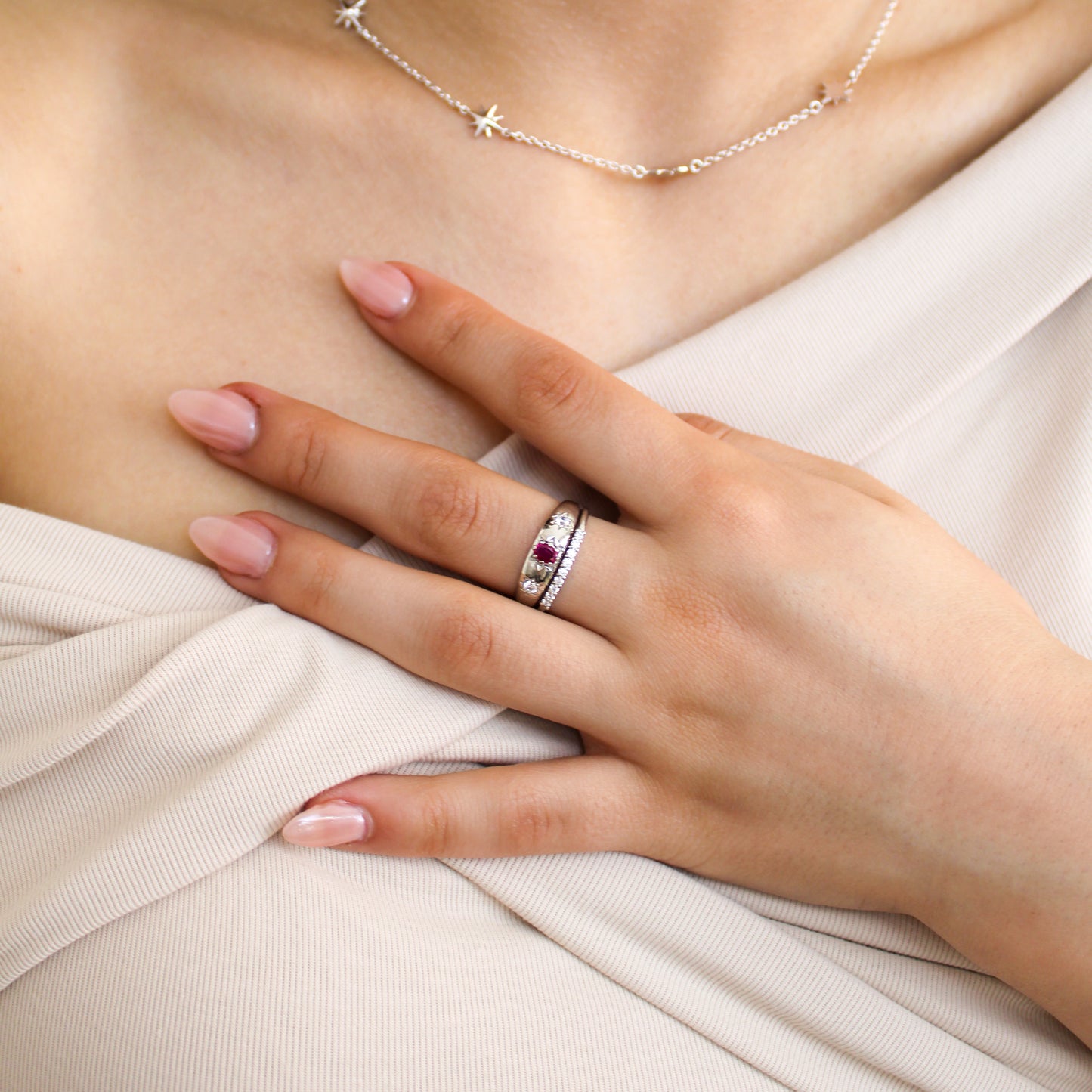 Rose from Roma Ring sterling silver close-up on model hand, domed pink CZ center with star-set white CZ stones, Ether Jewelry