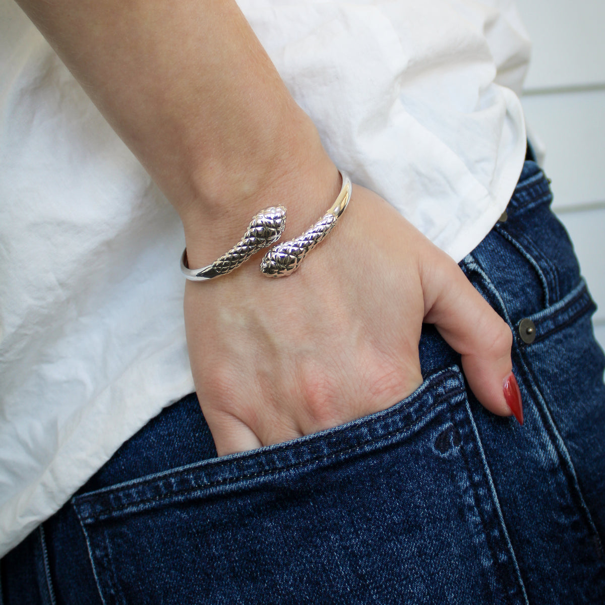 Serpentine Bracelet in sterling silver on model hand in pocket, coiled snake scale texture bangle, Ether Jewelry