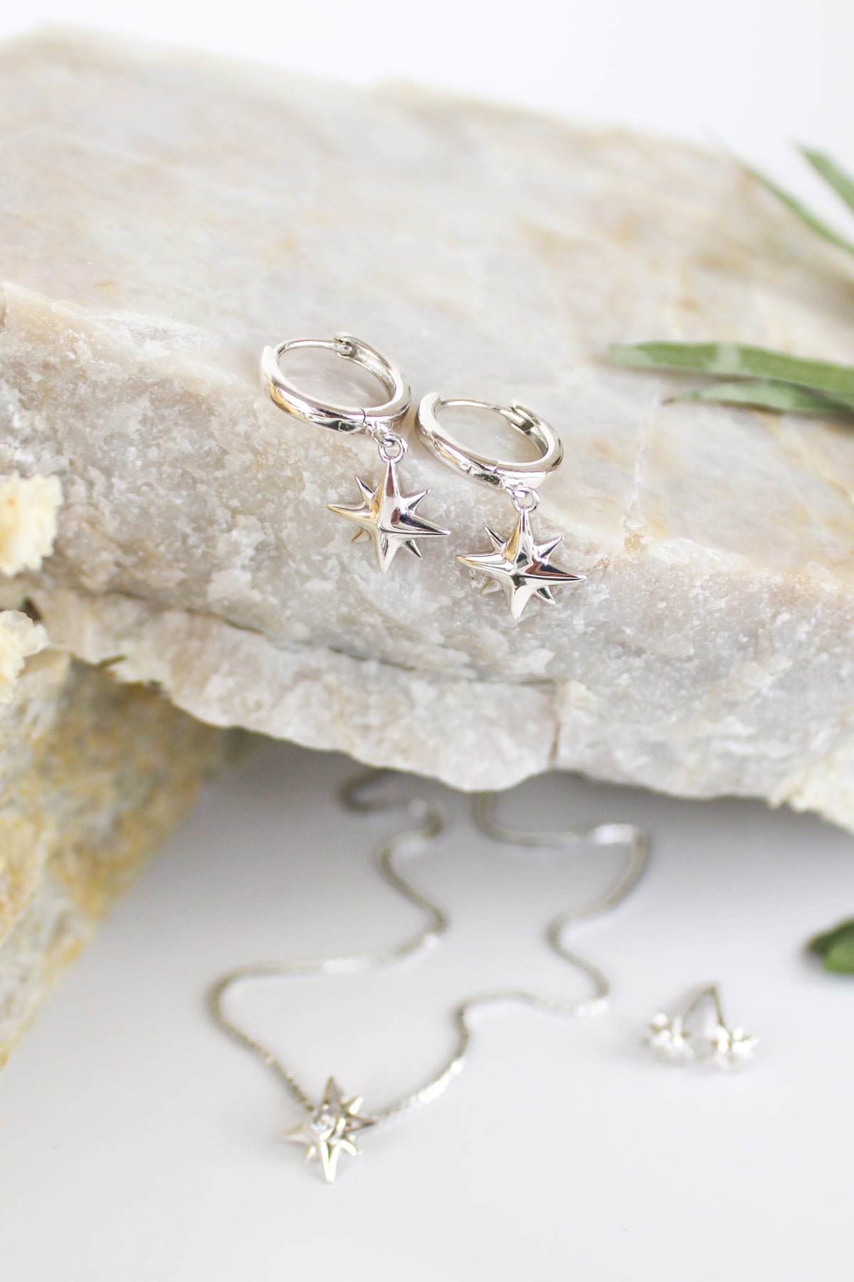 Stella Hoops in sterling silver staged on marble with other pieces, solid north star huggie hoop earrings, Ether Jewelry