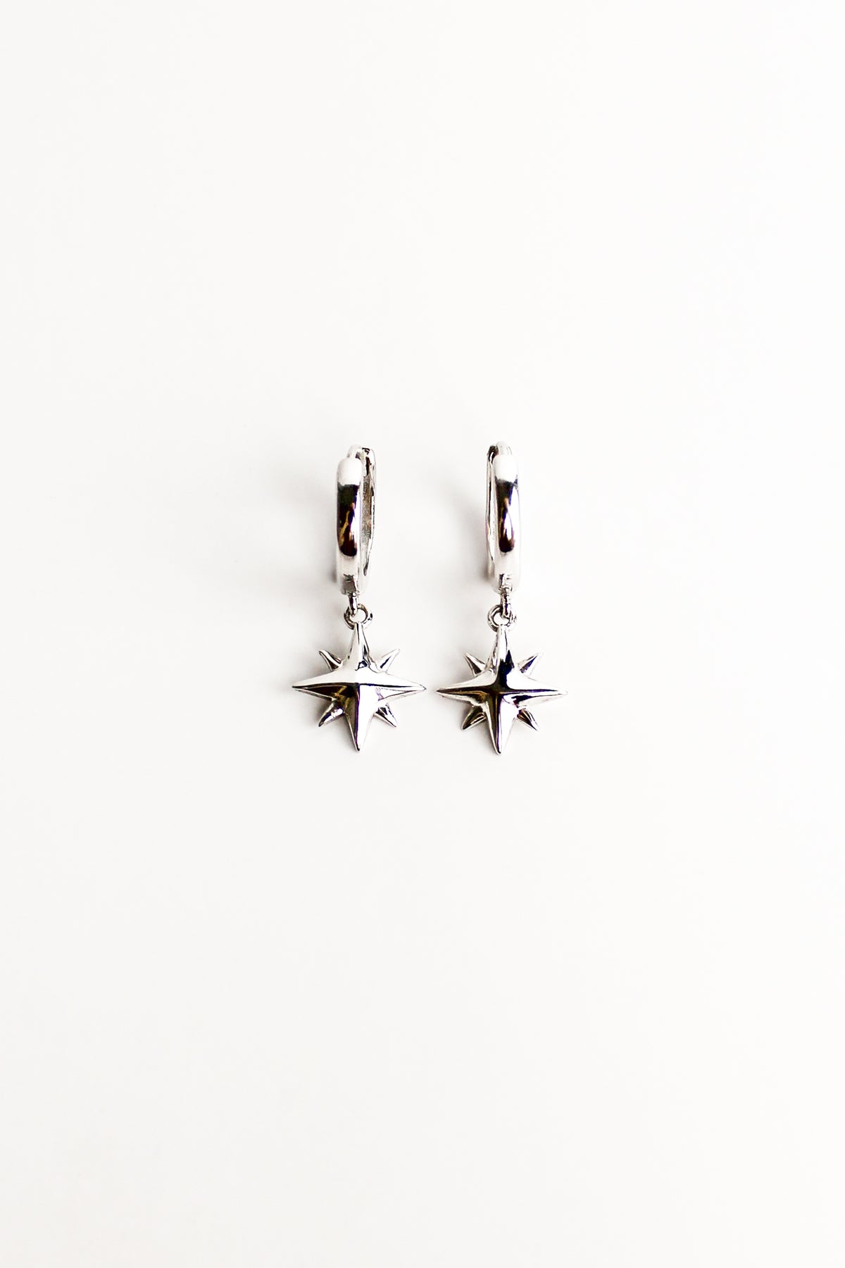 Stella Hoops in sterling silver, solid north star charm drop huggie hoop earrings, white background, Ether Jewelry