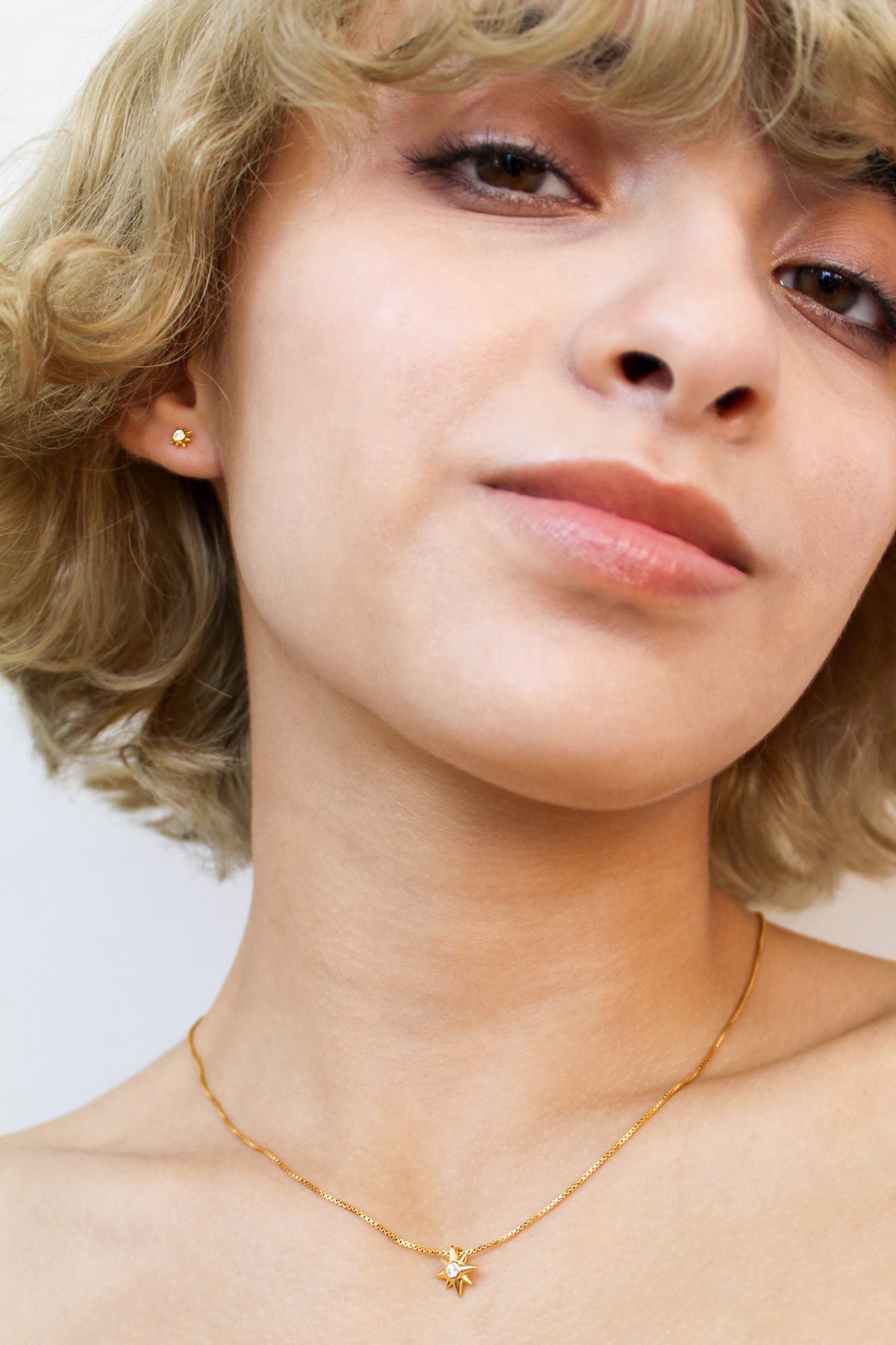18k gold vermeil Stella Stud Earrings on smiling model, north star CZ stud earrings, Ether Jewelry