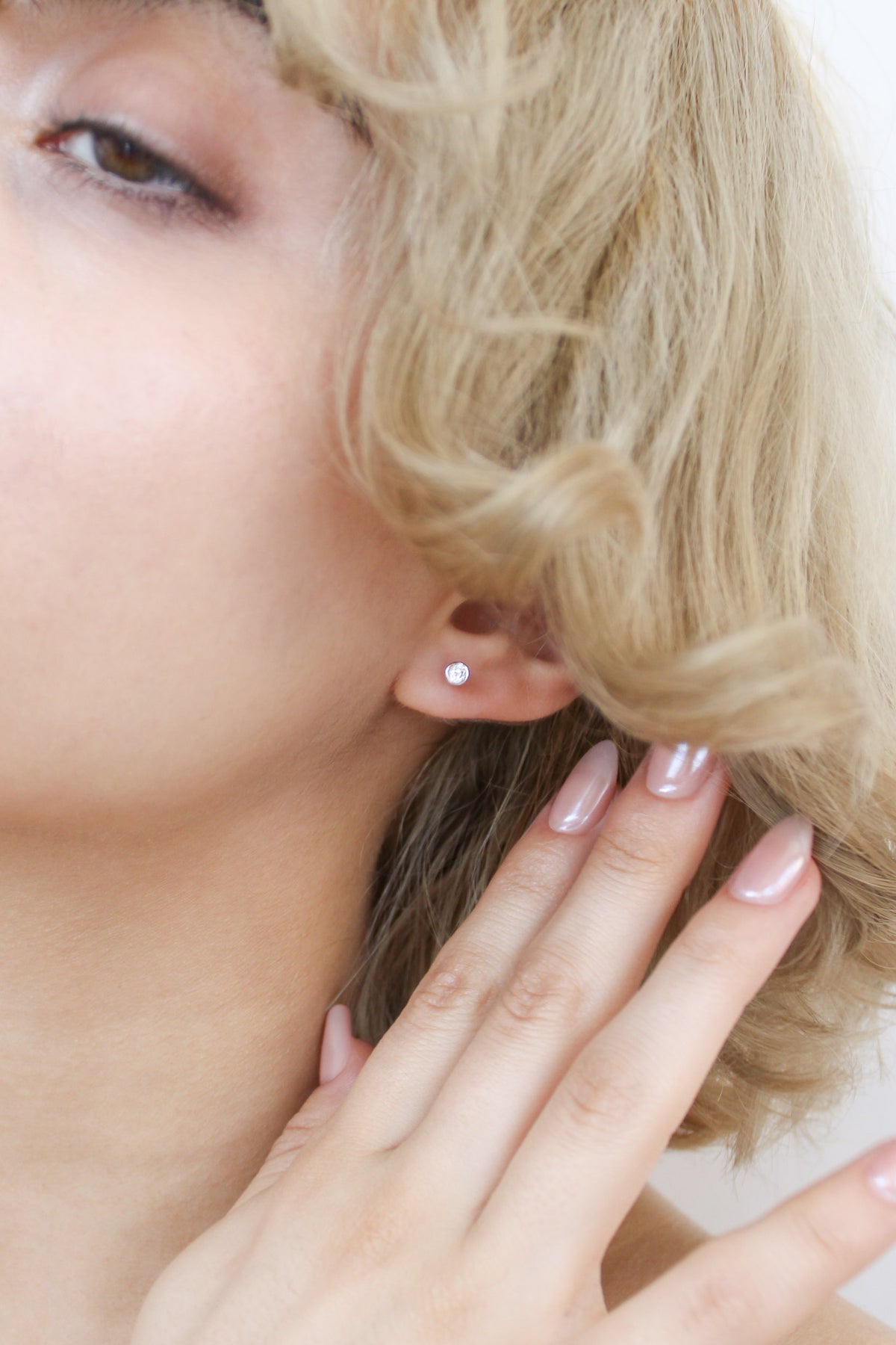 Sterling silver Vesta Stud Earrings on model pushing hair away to reveal earring, bezel CZ stud earring, Ether Jewelry