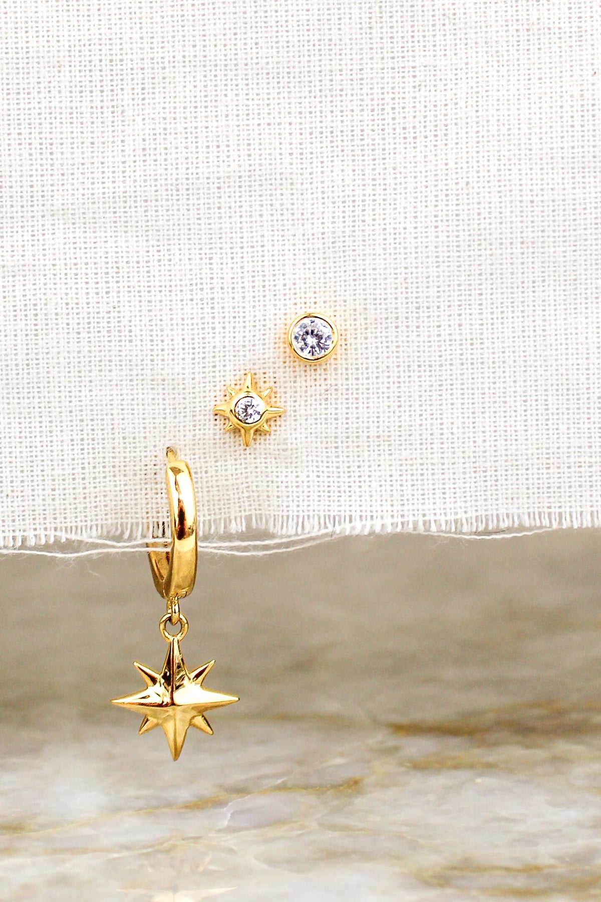 Vesta Stud Earrings 18k gold vermeil staged on natural fabric with all three earrings above marble, Ether Jewelry