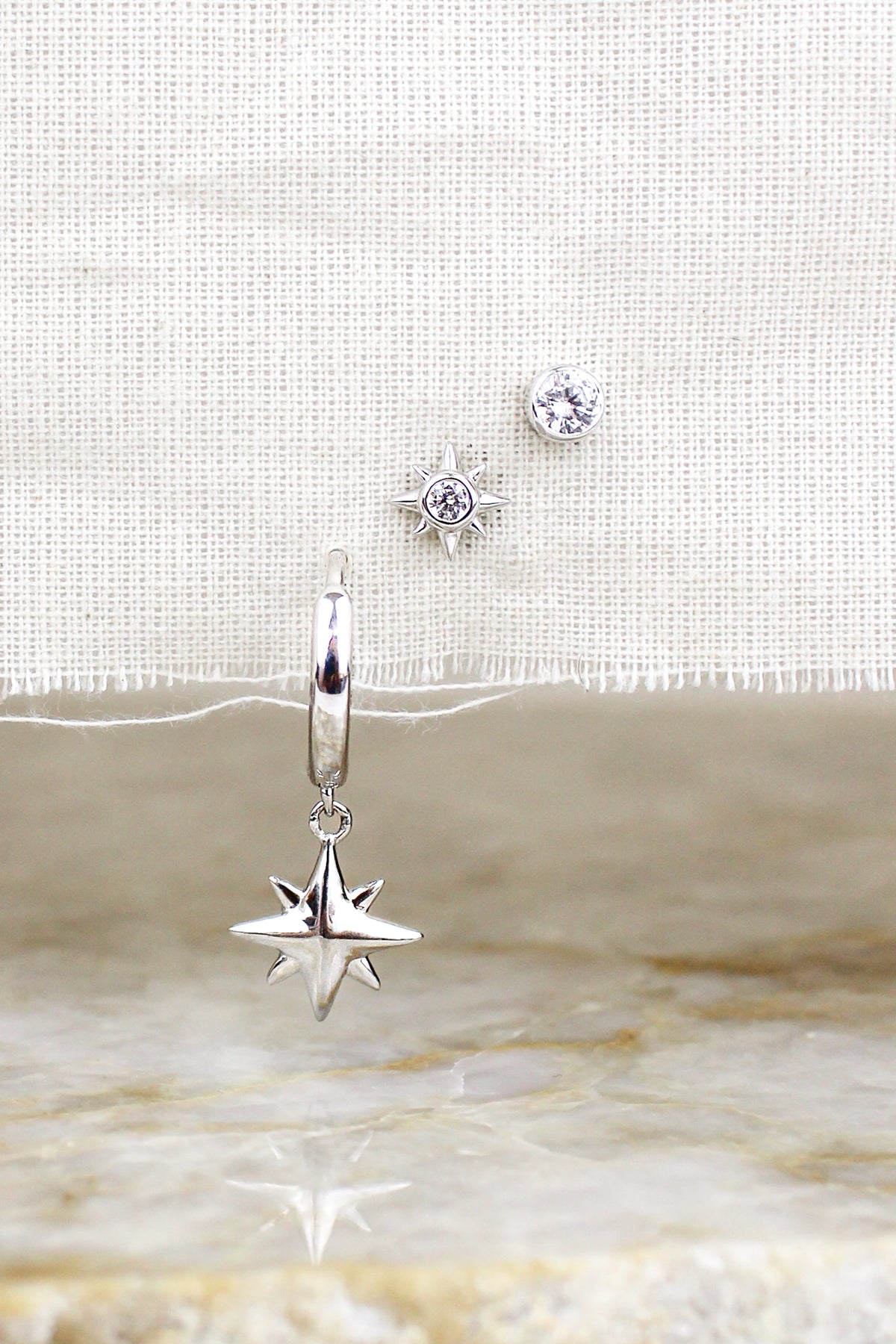 Stella Stud Earrings sterling silver staged on natural fabric with all three earrings above marble, Ether Jewelry