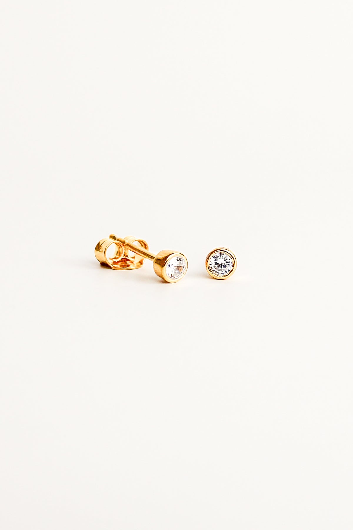 esta Stud Earrings in 18k gold vermeil, dainty bezel-set round CZ stud earrings, white background, Ether Jewelry