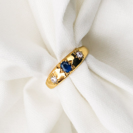 Victorian Roma Ring in 18k gold vermeil, domed gypsy band with blue CZ center and two star-set white CZ side stones on white fabric, Ether Jewelry