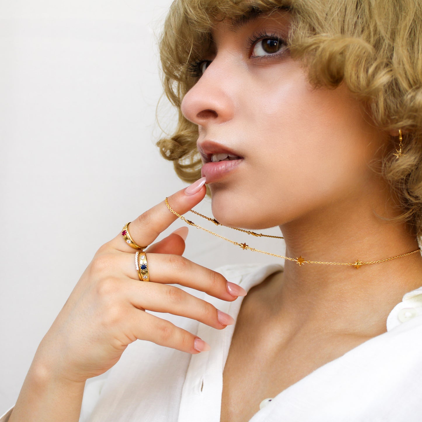 Victorian Roma Ring in 18k gold vermeil on model holding necklace, domed blue CZ gypsy set band side view, Ether Jewelry