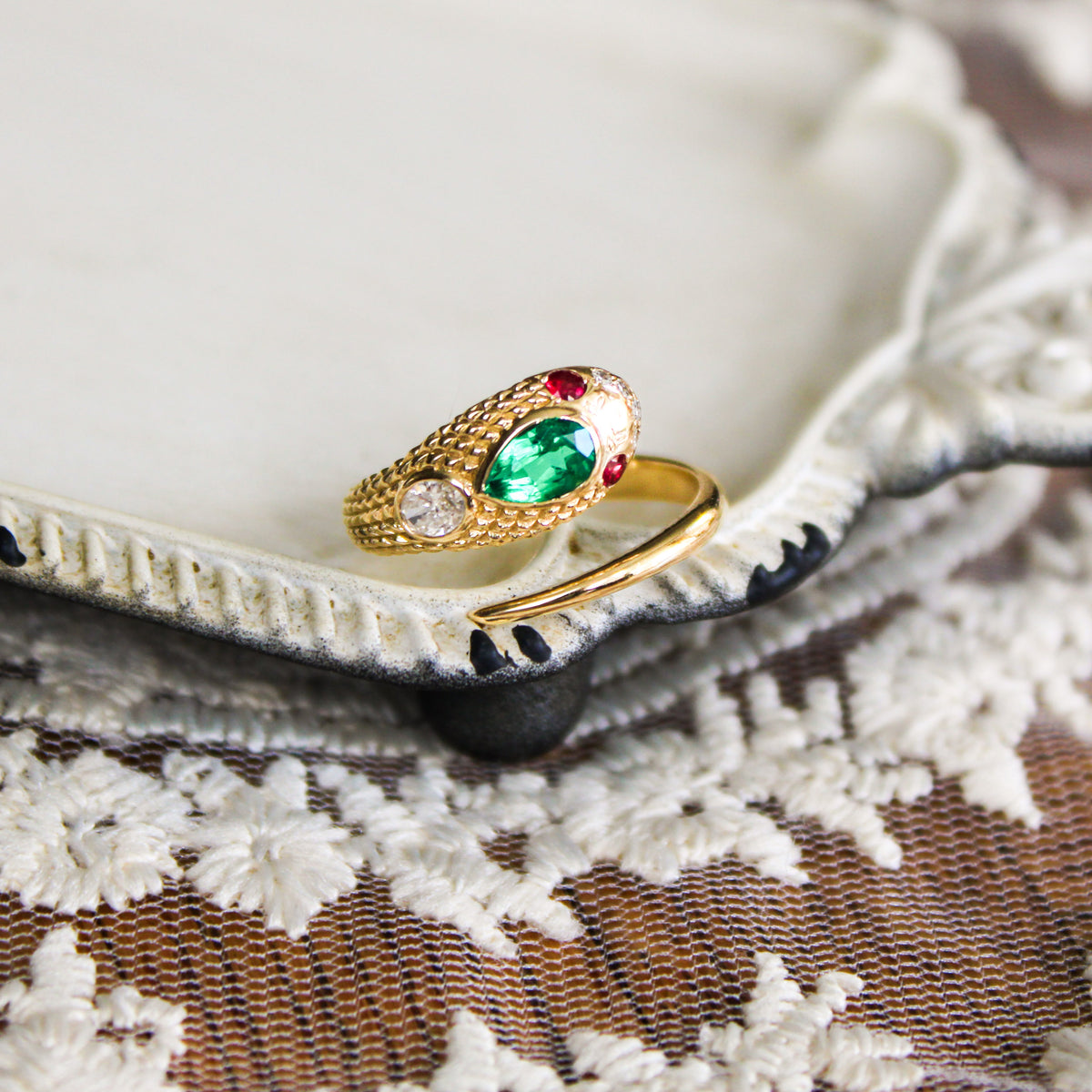 Queen Victoria ring in 14k solid gold on tray showcasing lab-grown emerald pear stone ruby eyes and diamond accents, Victorian serpent ring, Ether Jewelry